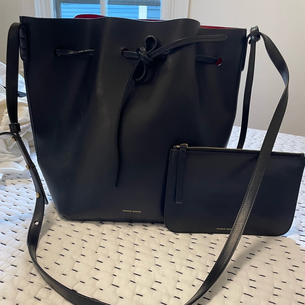Mansur Gavriel large black bucket bag with red interior.